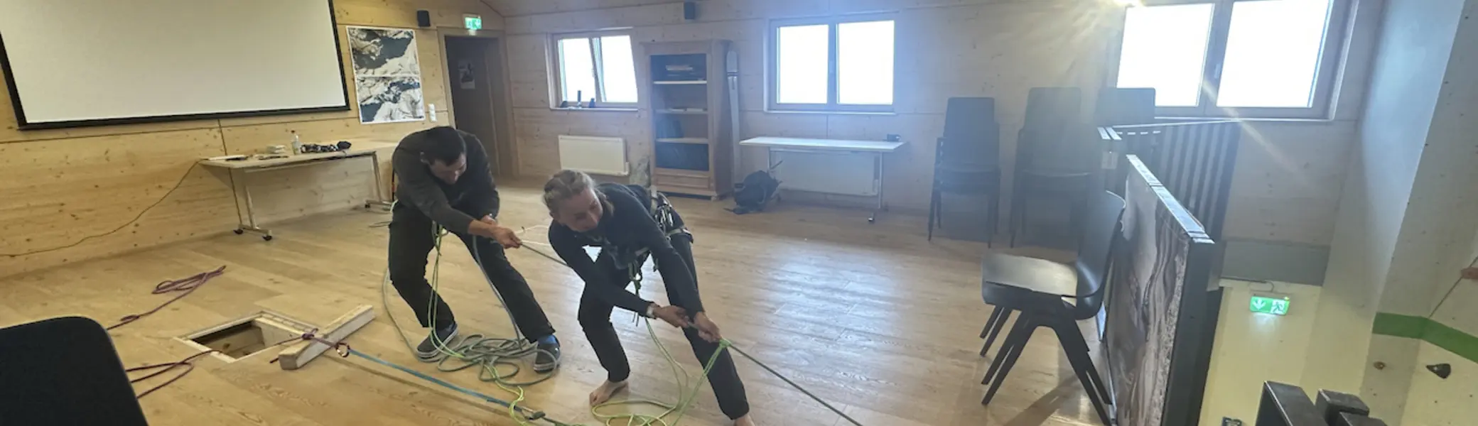 Teilnehmende trainieren Spaltenrettungstechniken im Seminarraum der Hütte | © DAV-Starnberg/Angelika Kaunicnik