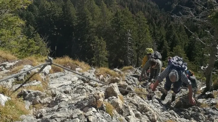 Weg Ettal - Zwei Bergsteiger kraxeln am Klettersteig bei sonnigem Wetter, unter ihnen ein Nebelmeer | © DAV Starnberg 