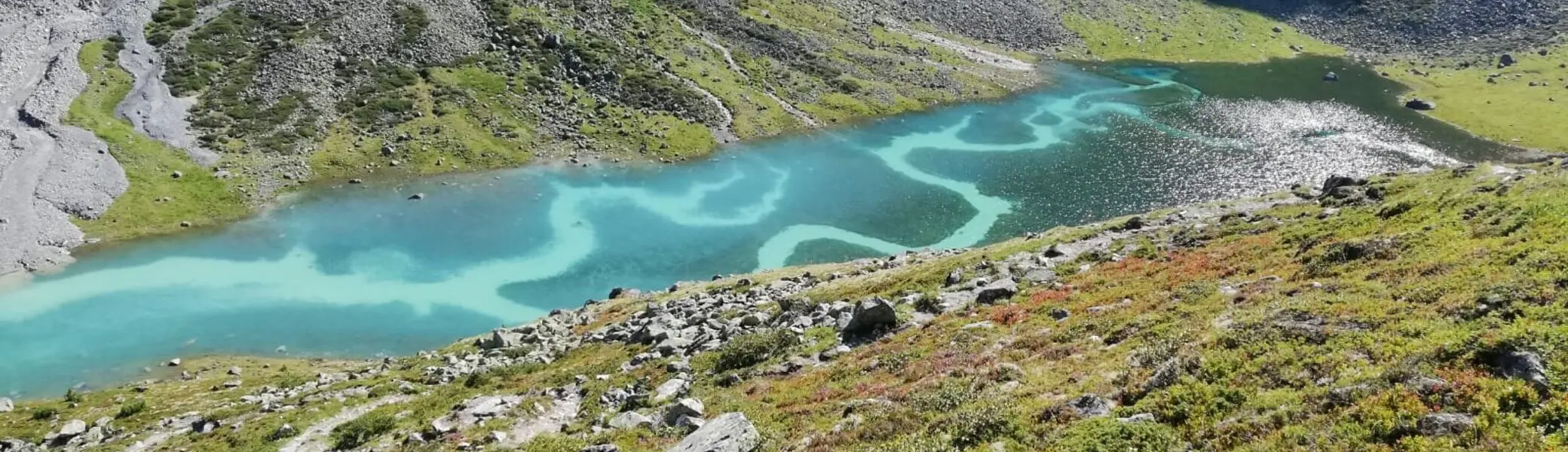 türkiser Smaragdsee mit hellen Strömungsarmen im Weitwinkel mit Abhang im Vorder- und Hintergrund | © DAV Starnberg