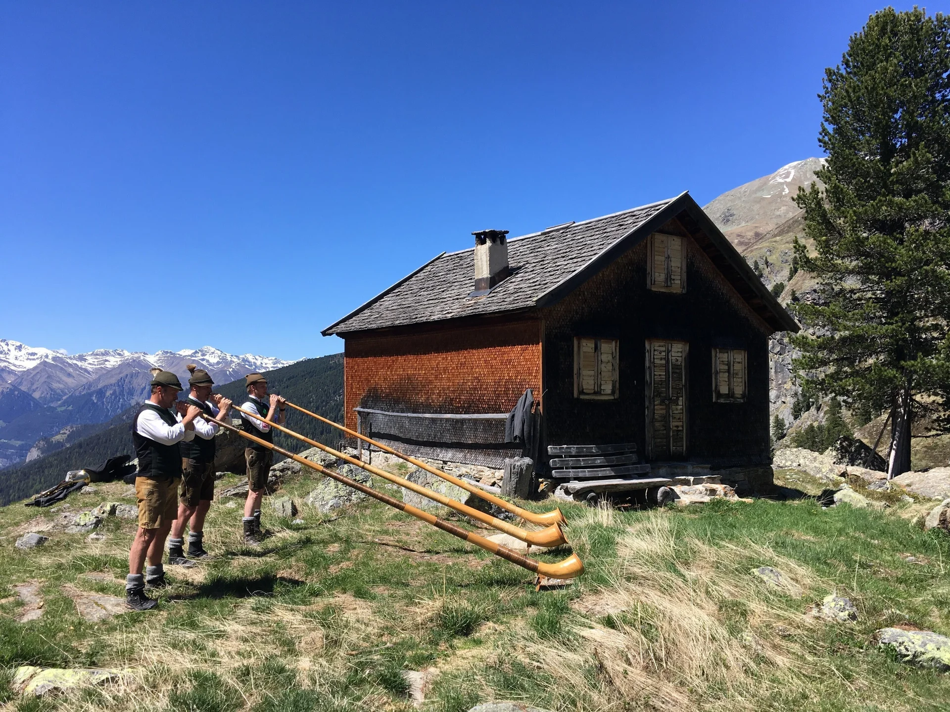 Hohenzollernhaus Alphornbläser vor Nebenhütte und Berggipfeln | © DAV Starnberg