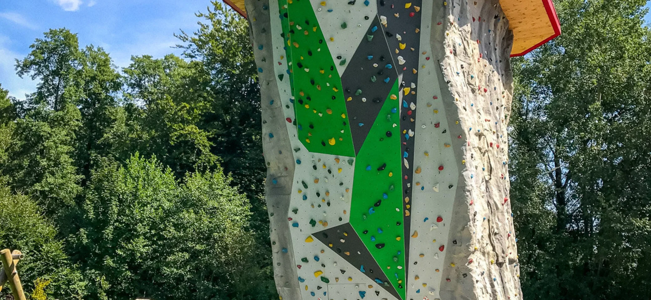 Foto Kletterturm mit Bank, Wiese, Reck, Stein mit Slackline, Wald im Hintergrund | © Walltopia: Bild aufgerufen am 28.11.2024 von: https://walltopia.com/de/projects/dav-starnberg-outdoor-tower/