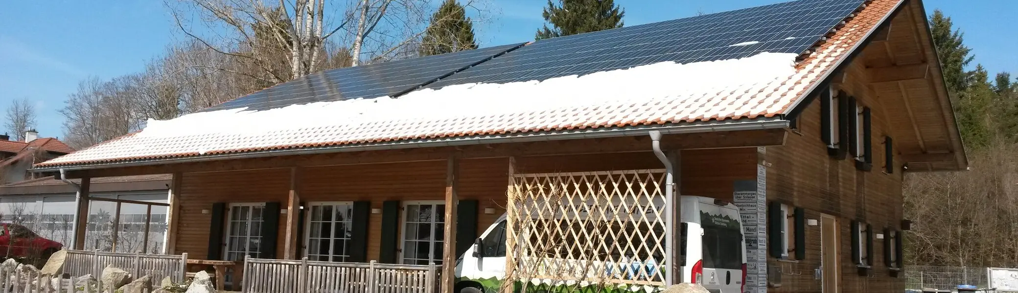 Vereinsheim von der Einfahrt aus mit Schnee auf dem Dach, Vereinsbus, Steingarten | © DAV Starnberg